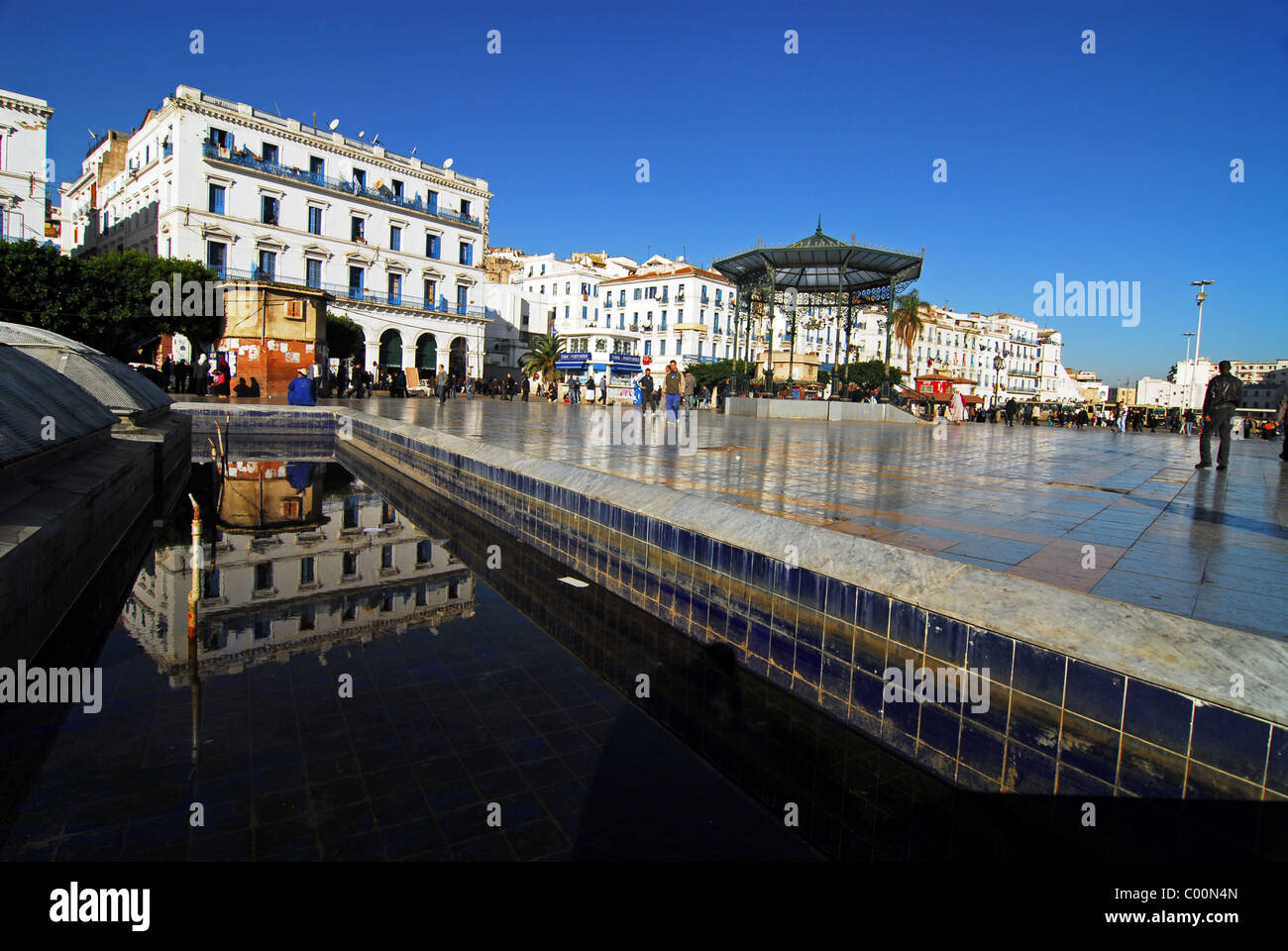 L'Algérie, Alger, la réflexion sur la construction de piscine avec des gens qui marchent sur un sol carrelé en arrière-plan Banque D'Images L'Algérie, Alger, la réflexion sur la construction de piscine avec des gens qui marchent sur un sol carrelé en arrière-plan Banque D'Images