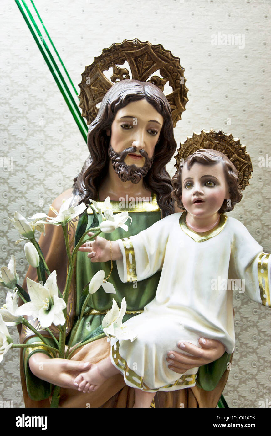 L'enfant Jésus porté par Saint Joseph holding white lilies & price tag statue religieuse en plâtre en vitrine Mexico City Banque D'Images