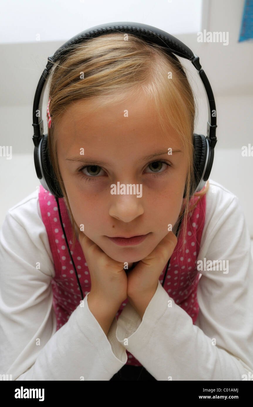 Fille, 9 ans, avec des écouteurs Banque D'Images