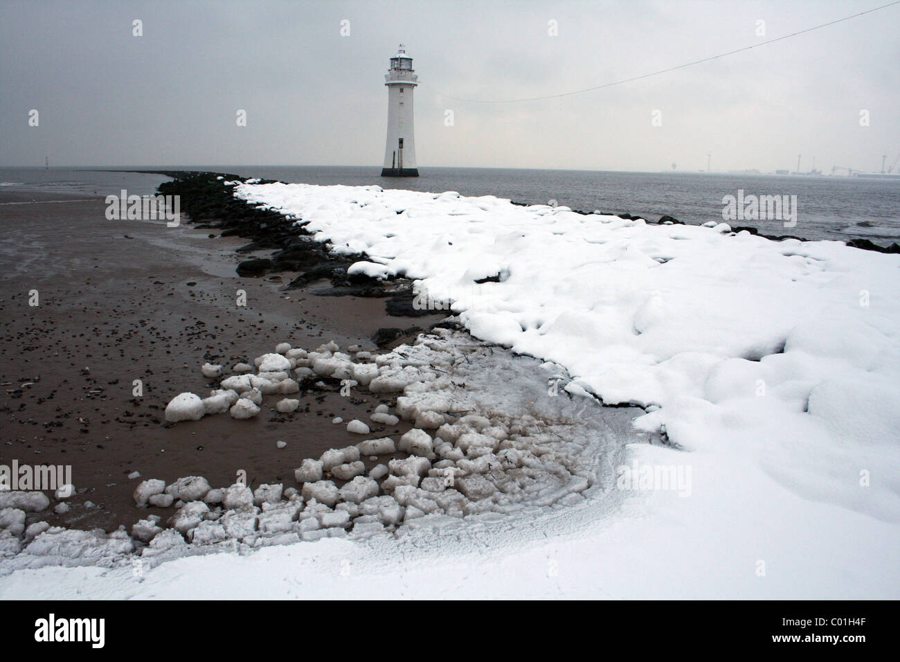 Nouveau phare de Brighton et la défense de la mer couverte de neige, l'épi de Wallasey, Wirral, Merseyside, Royaume-Uni Banque D'Images