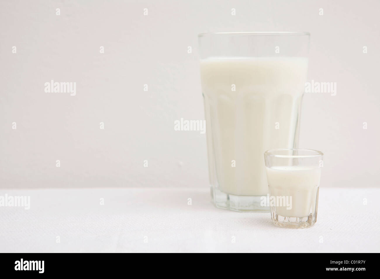 Verres de lait, petits et grands, blanc Banque D'Images