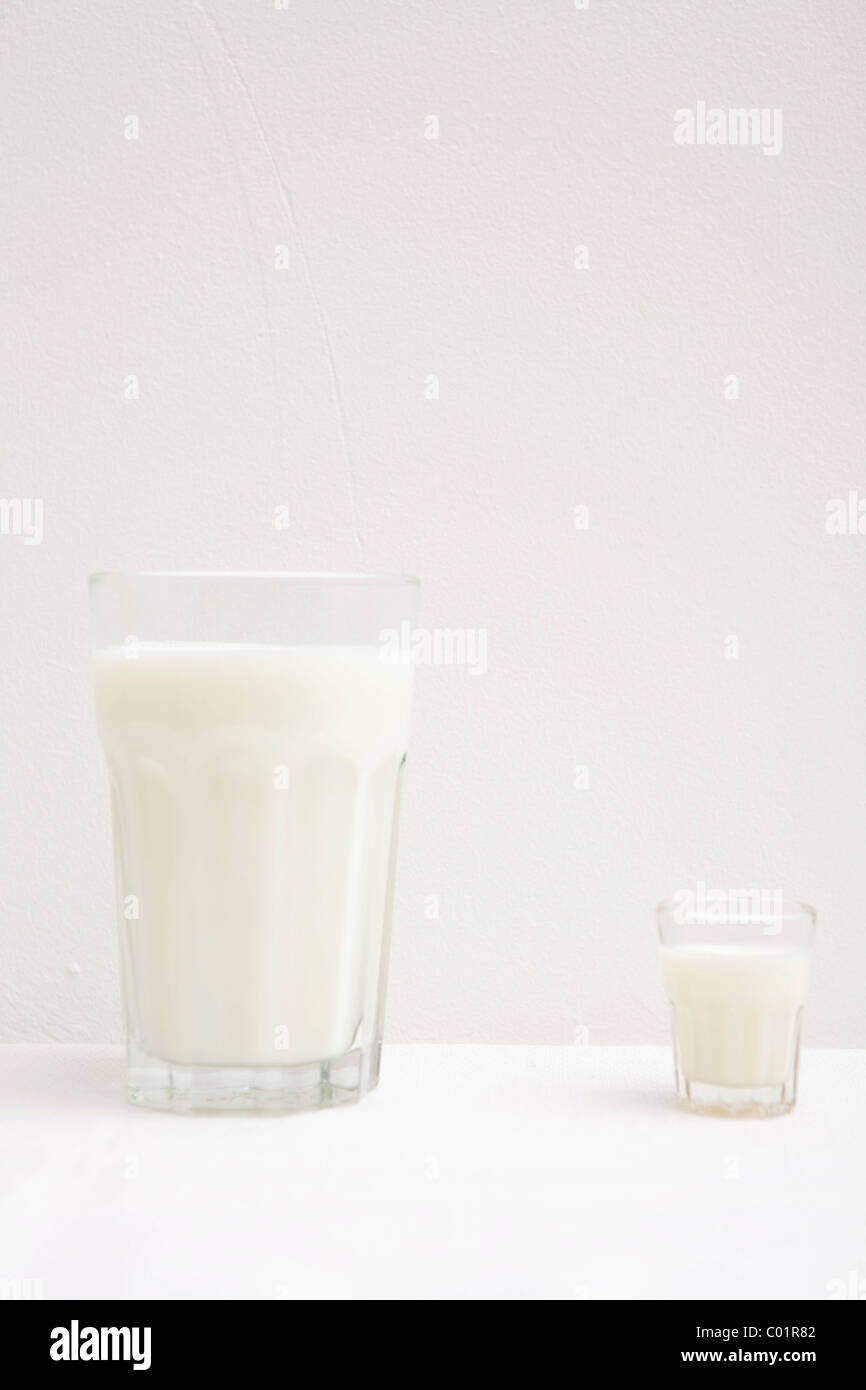 Verres de lait, petits et grands, blanc Banque D'Images