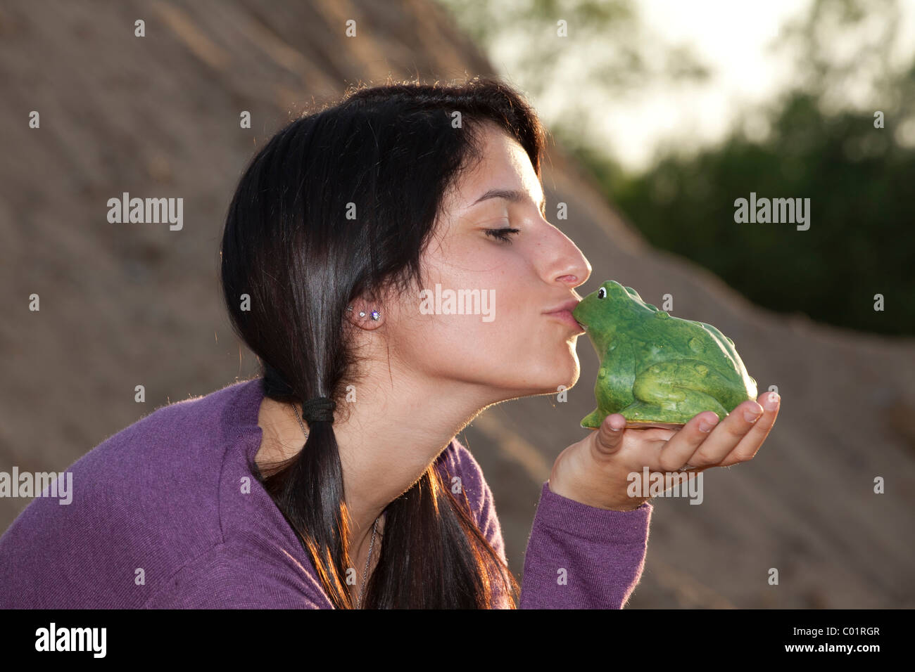 Jeune femme s'embrasser une grenouille Banque D'Images