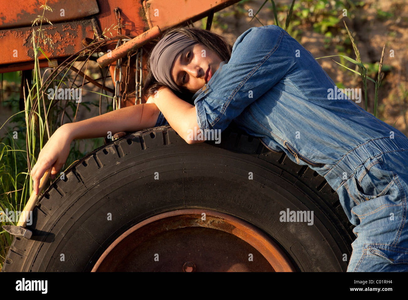 Jeune femme portant une salopette denim en face de machines industrielles Banque D'Images