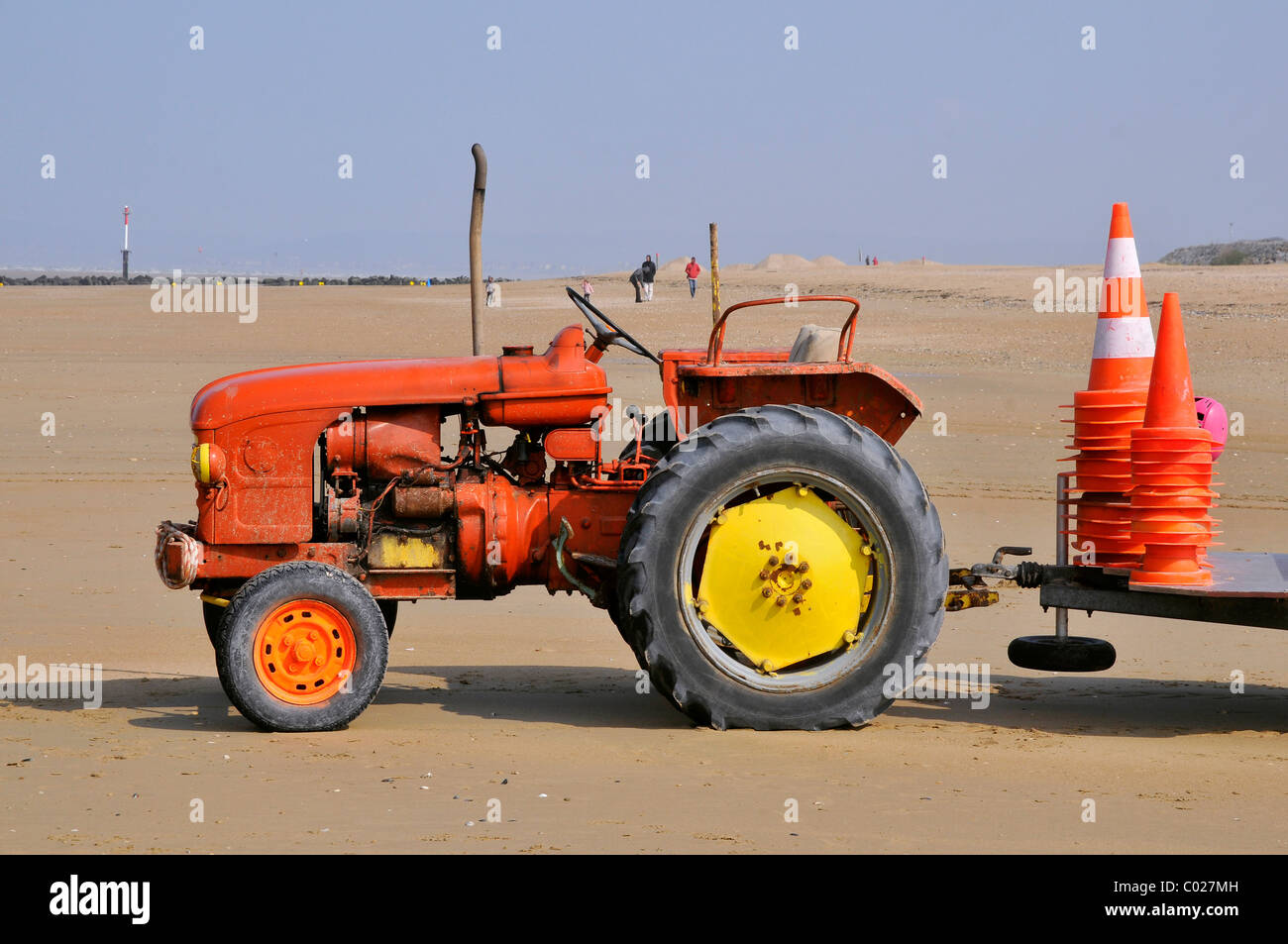 Tracteur rouge sur la plage de Ouistreham en Normandie en France pour le transport de petits bateaux Banque D'Images