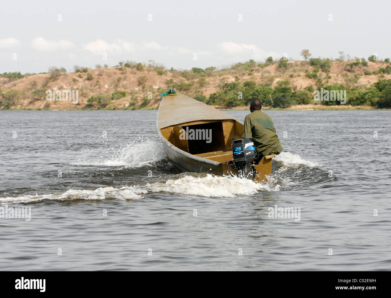 Un ranger de l'Uganda Wildlife Authority dans un bateau sur le Nil au-dessous de la Paraíba près de Murchison Falls Banque D'Images