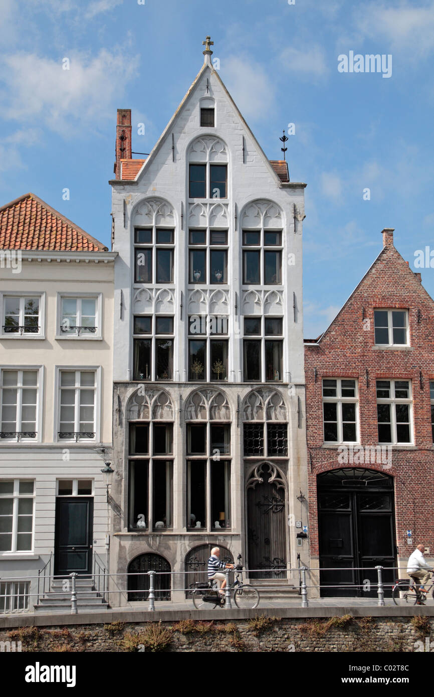 Les cyclistes en passant en face d'un impressionnant grand canal Spiegelrei sur, dans le quartier historique de Bruges (Brugge), Belgique. Banque D'Images