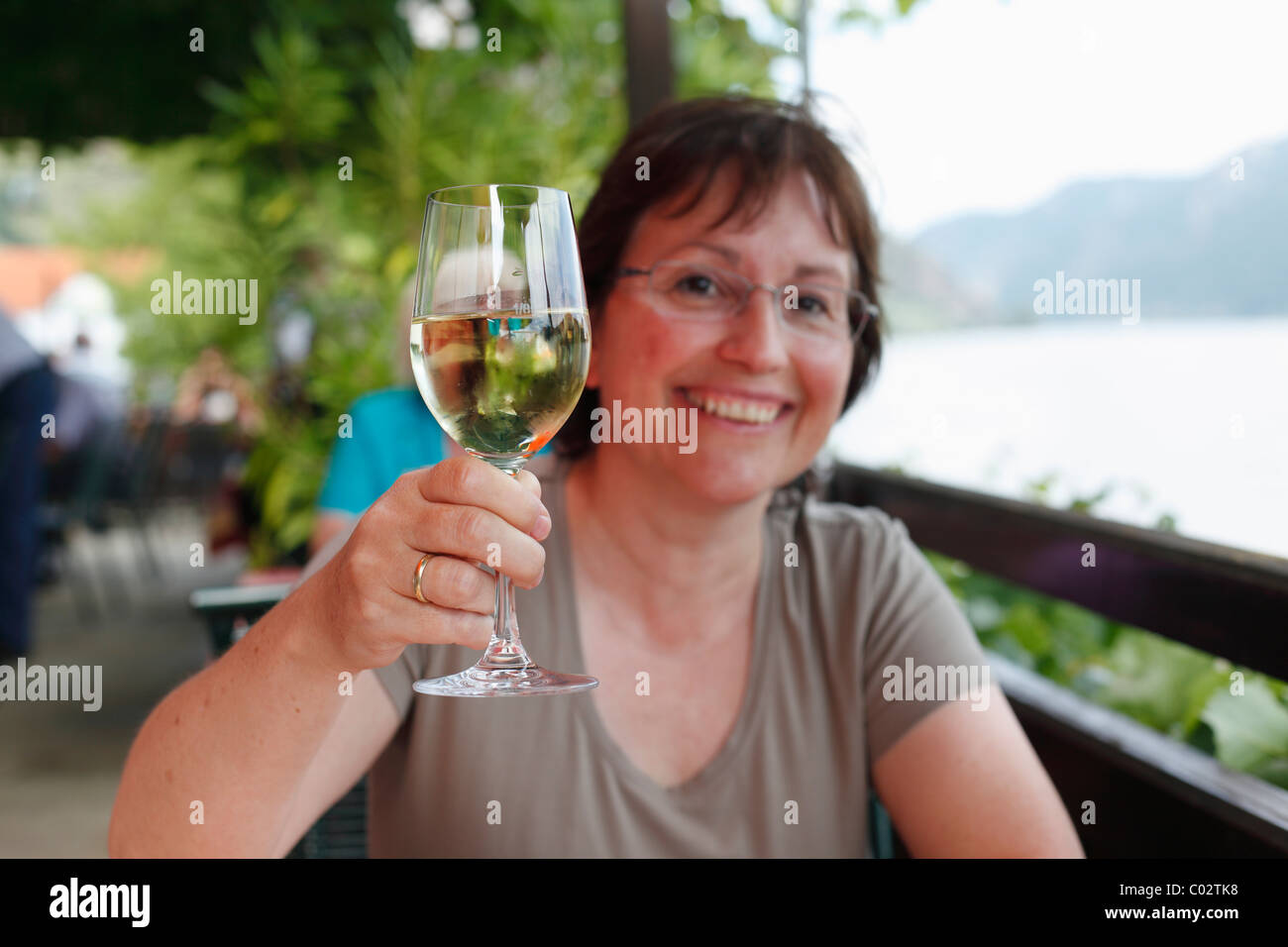 Femme avec un verre de vin blanc dans un café en bord de mer sur le Danube, Spitz, Wachau, Waldviertel, Basse Autriche, Autriche, Europe Banque D'Images