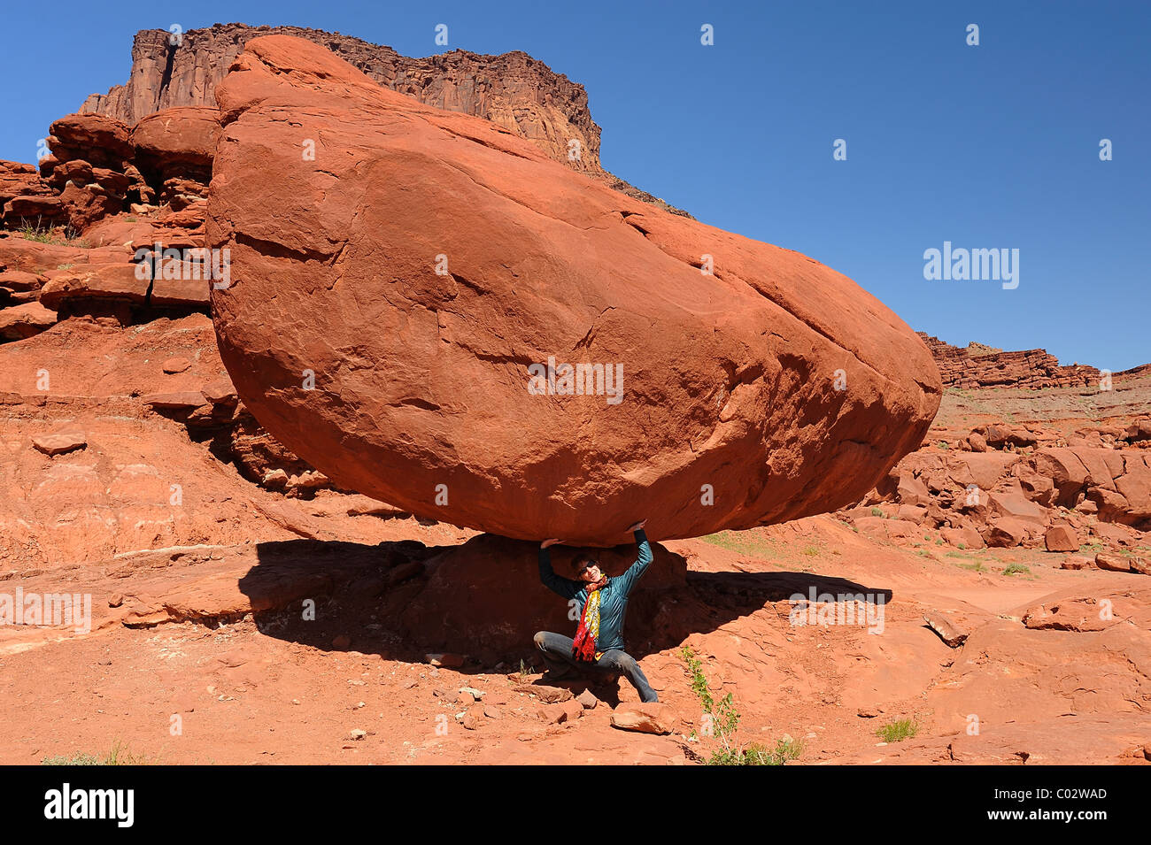 Femme simulant la valeur comptable d'un rocher dans le Parc National de Canyonlands, Île dans le ciel, près de Moab, États-Unis Banque D'Images