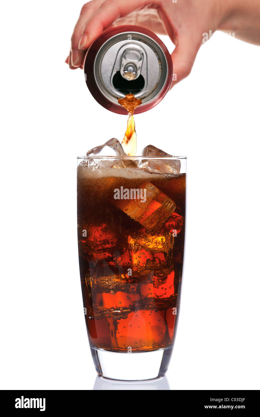 Photo de Cola est versé dans un verre avec des glaçons, en isolé sur un fond blanc. Banque D'Images