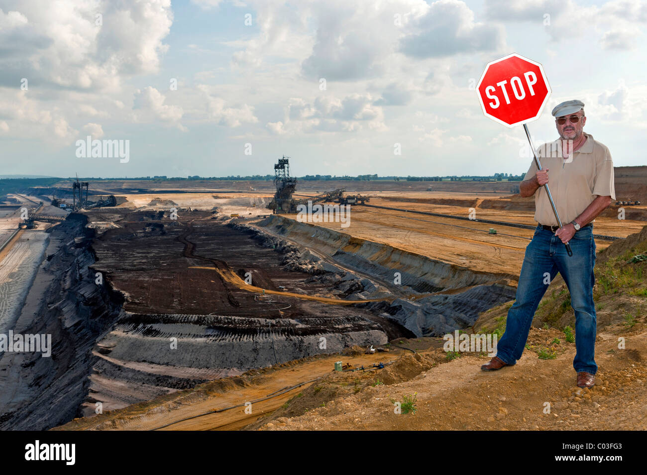 Homme debout sur le bord d'une mine à ciel ouvert, tenant un panneau d'arrêt, Grevenbroich, Rhénanie du Nord-Westphalie, Allemagne, Europe Banque D'Images