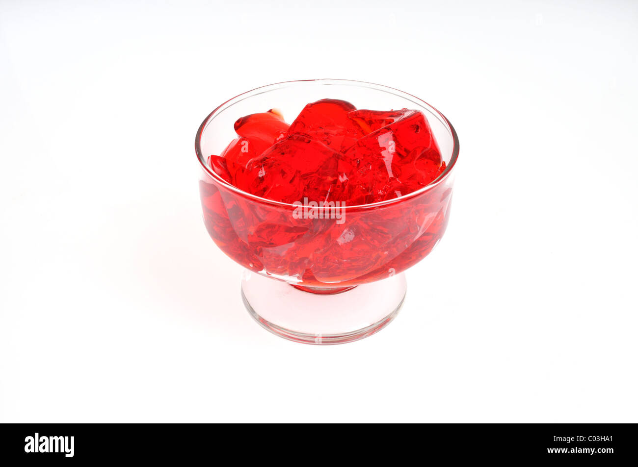 Jell-O aux fraises de gélatine dans un plat de service en verre sur fond blanc, isolé. Banque D'Images