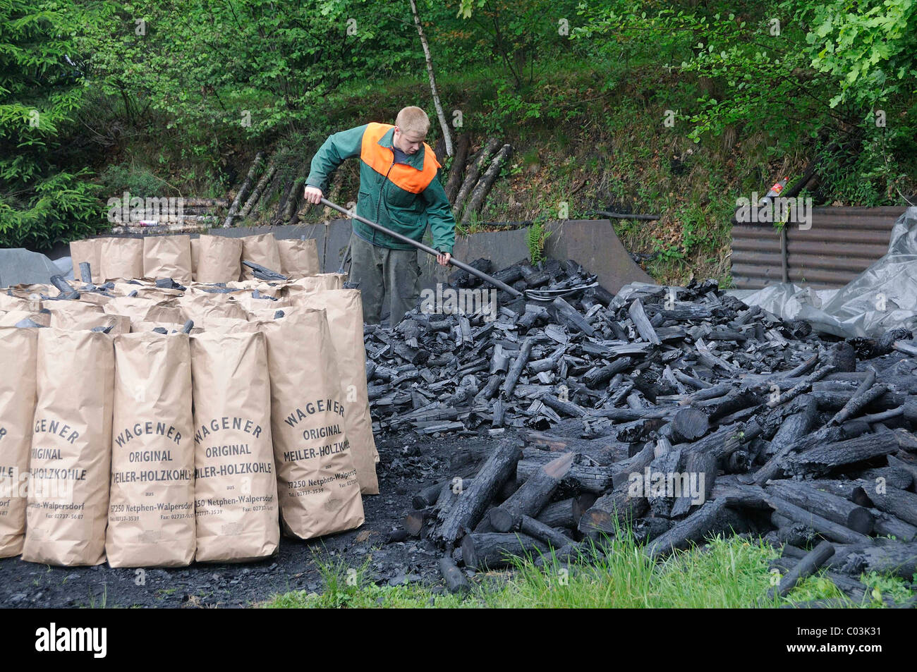 L'adjoint de Charburner avec le remplissage de sacs de charbon de bois, fini Walpersdorf, Düren, région Rhénanie du Nord-Westphalie Banque D'Images