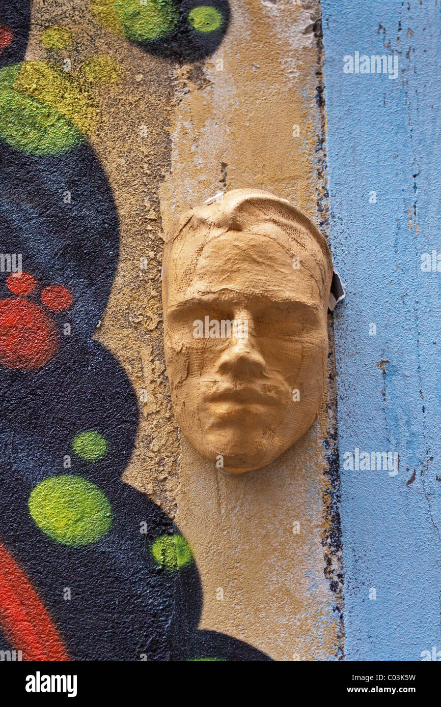 Masque d'un visage masculin dans la cour d'un immeuble Banque D'Images