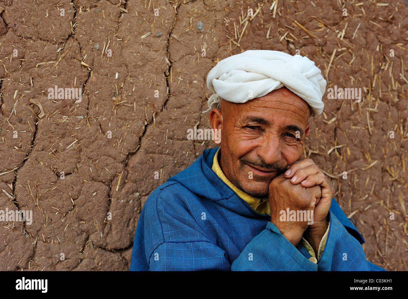 Portrait, personnes âgées homme berbère portant un turban en face d'un mur en terre, Haut Atlas, Maroc, Afrique Banque D'Images