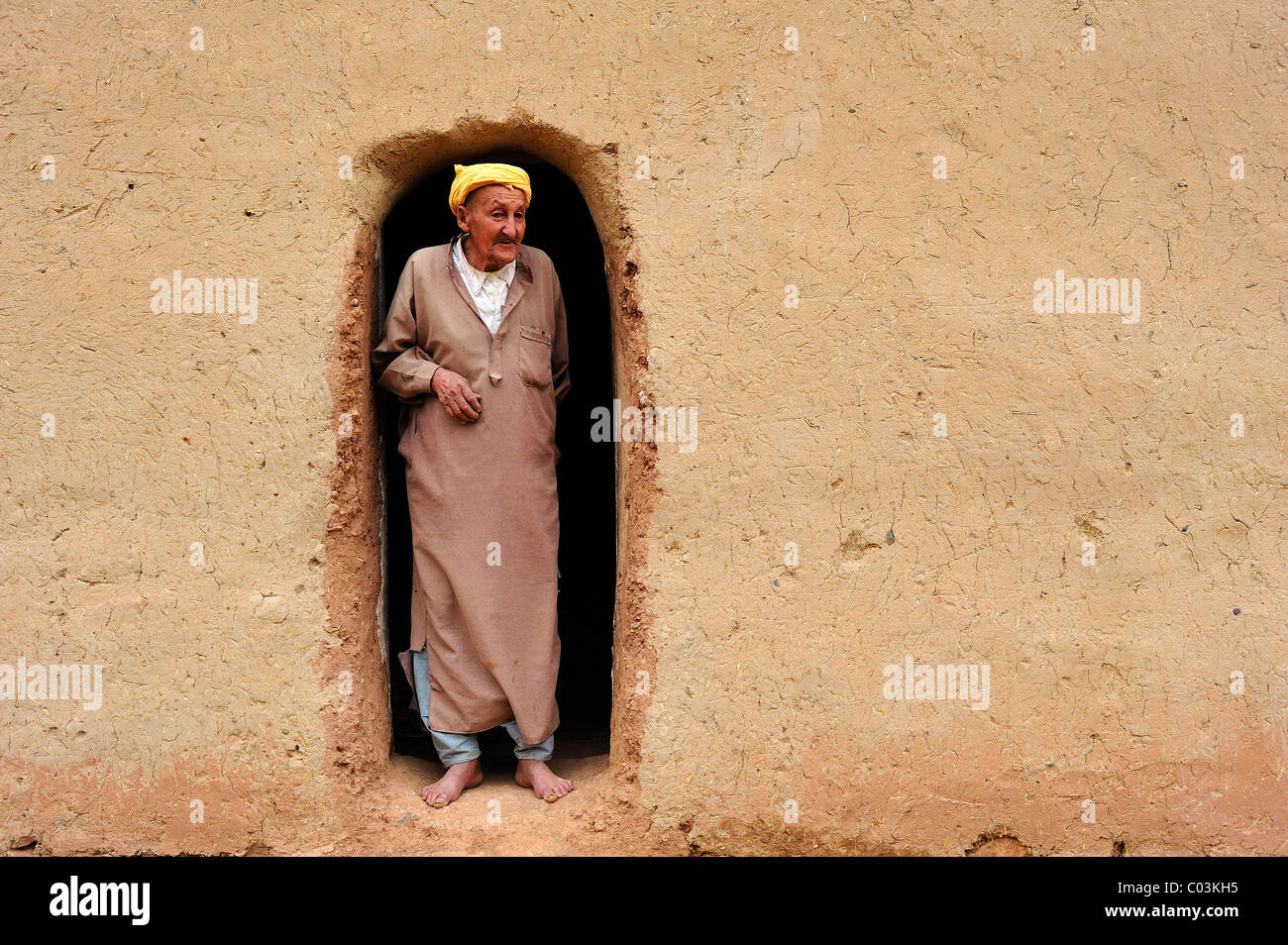 Personnes âgées homme berbère portant un turban à la recherche de l'entrée de sa maison de terre, Haut Atlas, Maroc, Afrique Banque D'Images