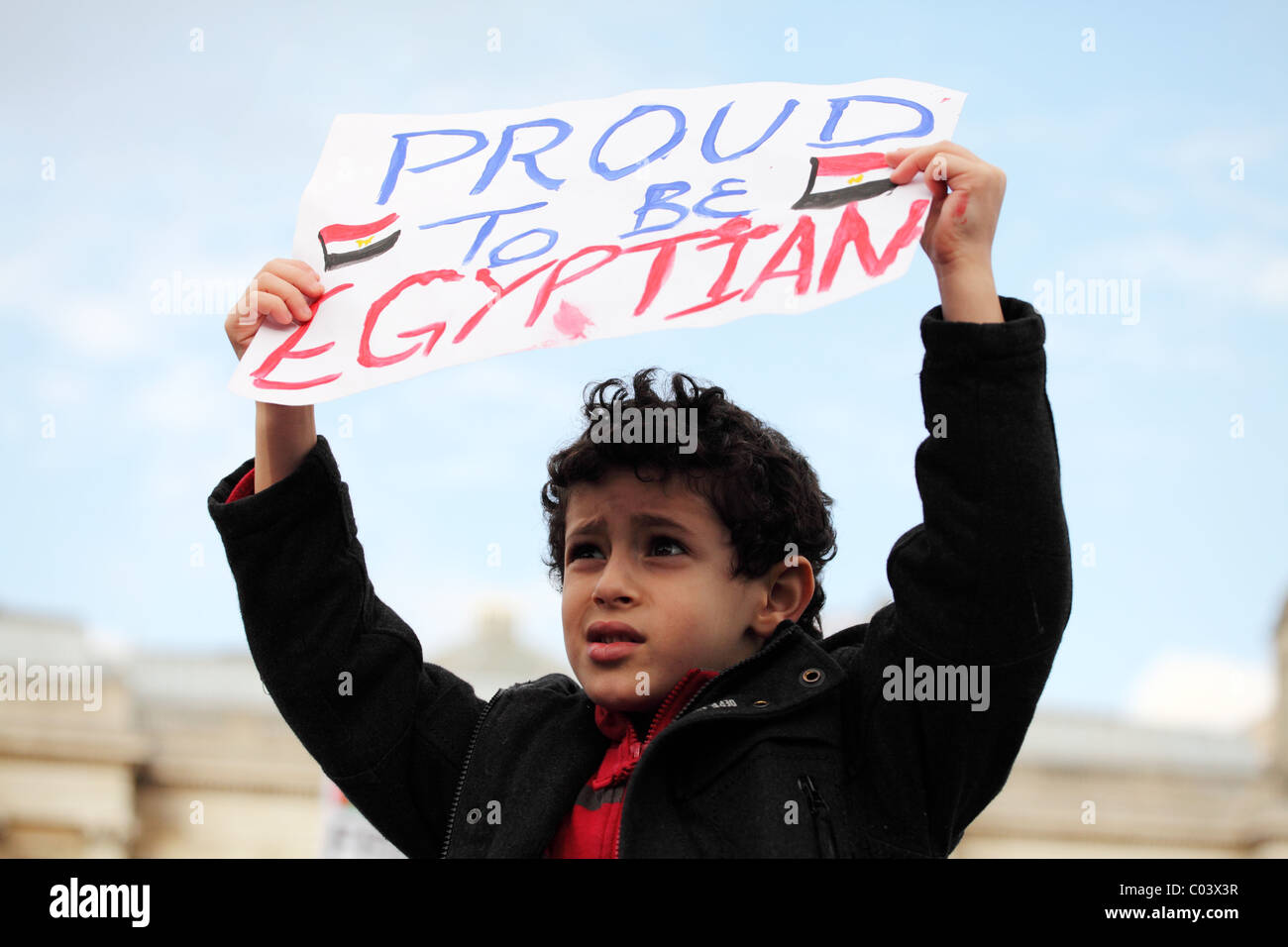 Jeune garçon tenant une bannière. En solidarité, au mépris : journée mondiale d'action pour l'Egypte. Trafalgar Square, Londres Banque D'Images