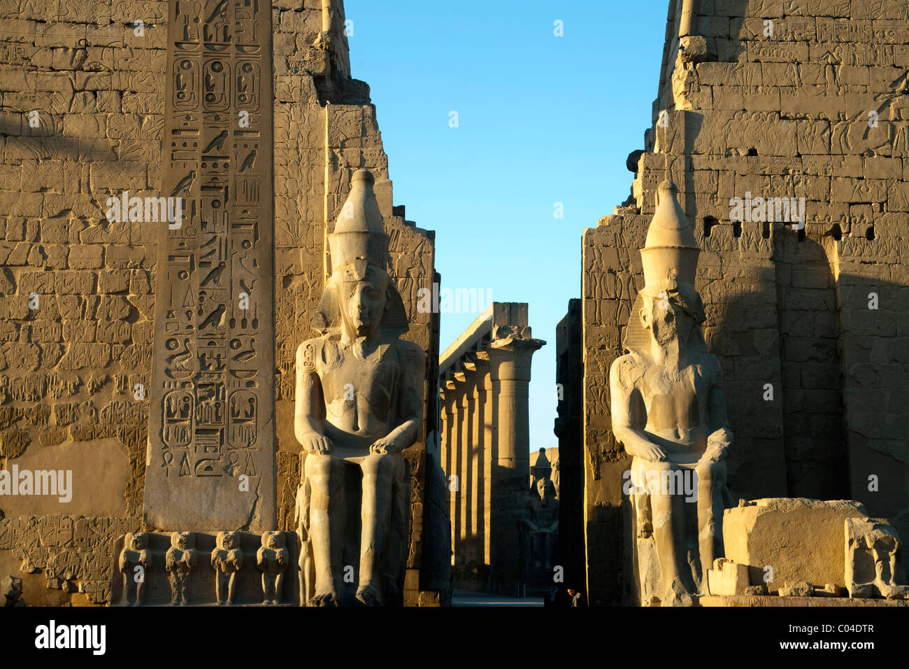 Aegypten, Luxor, Luxor-Tempel (Ipet-repasser), pylône mit den beiden Sitzstatuen des Ramses II., dahinter die Säulenkolonade Banque D'Images