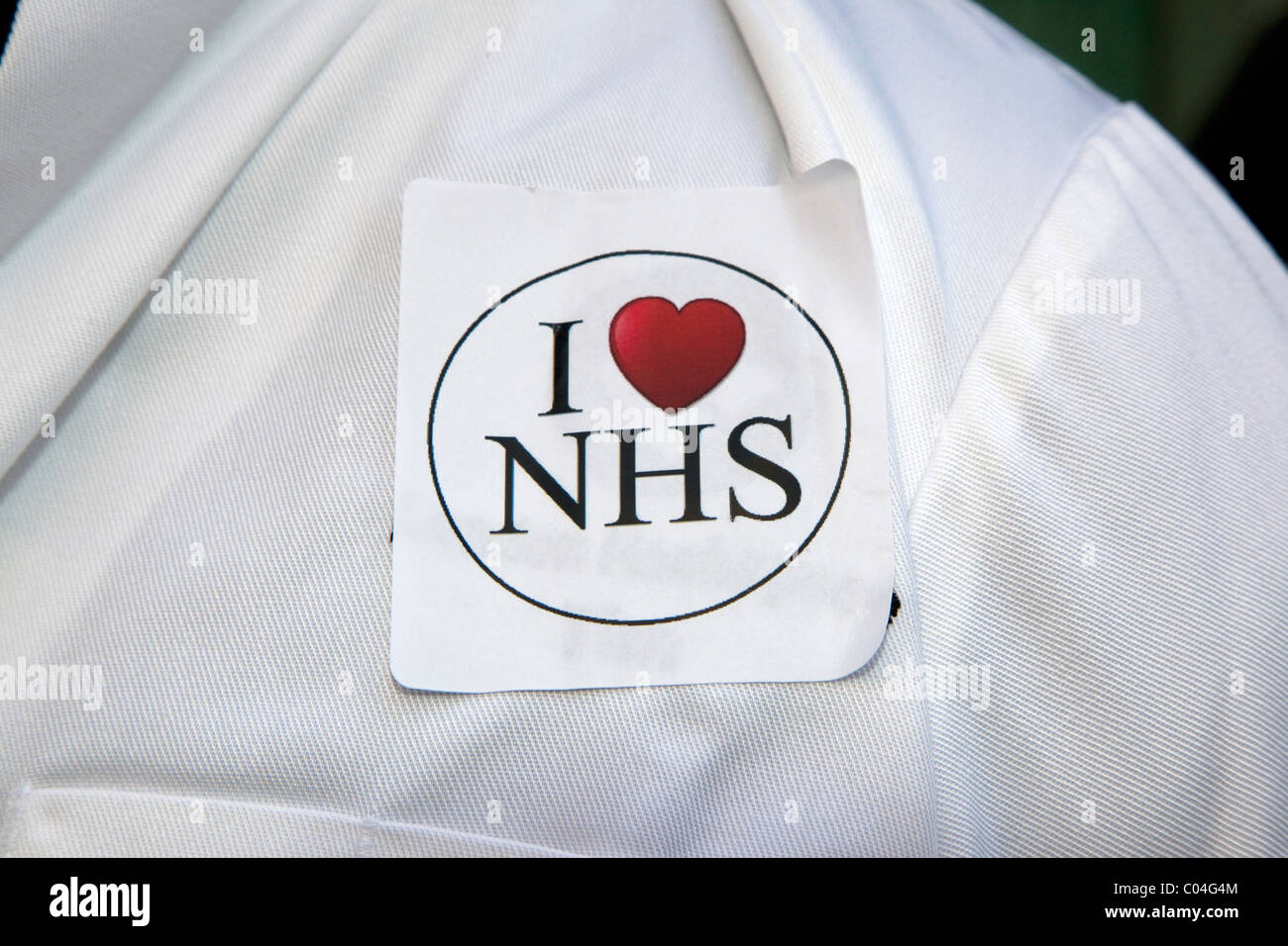 J'adore l'insigne NHS sur le manteau blanc du médecin pour protester contre les coupures NHS à Londres Banque D'Images