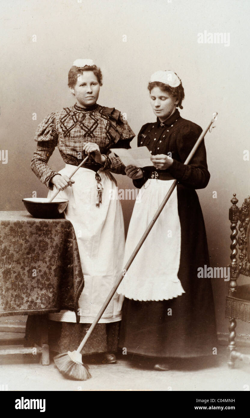 Domestiques victoriens servants, servantes filles ou femmes de ménage posant avec des ustensiles de cuisine et un balai, Angleterre c1880 carte-de-visite ou CDV Banque D'Images