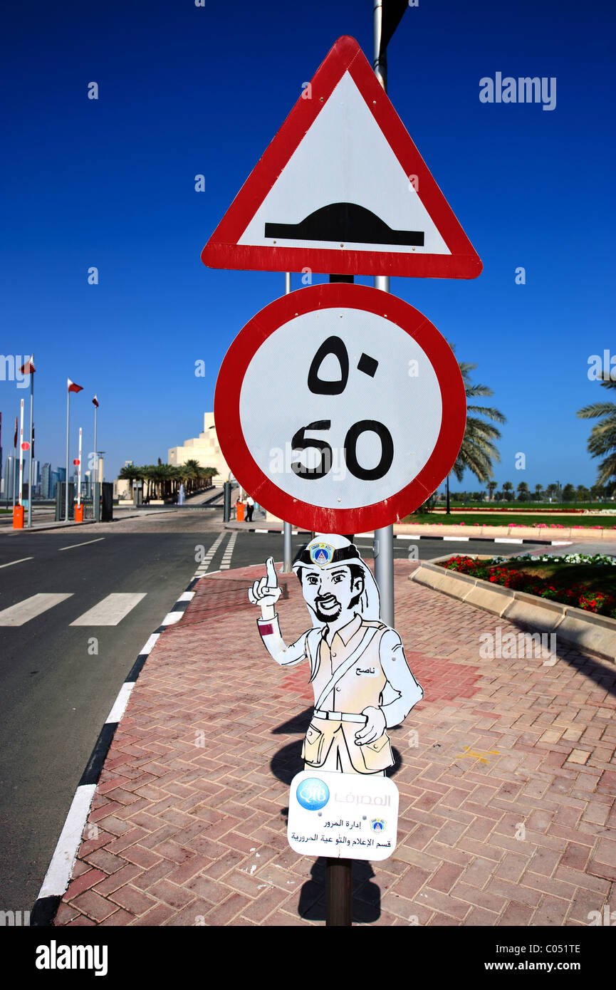 L'arabe signe sur Al Corniche Street, Doha, Qatar montrant limite de vitesse et d'avertissement de route cahoteuse Banque D'Images