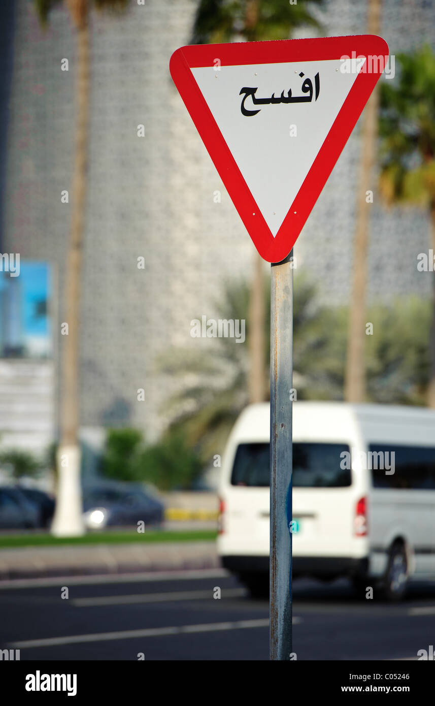 Signe de route sur Al Corniche Street, Doha, Qatar montrant céder en écriture arabe Banque D'Images