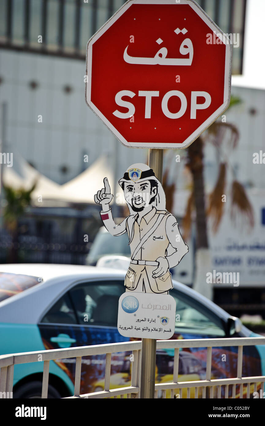 Panneau routier Arrêt sur Al-Corniche Street, Doha, au Qatar, en arabe et en anglais script Banque D'Images