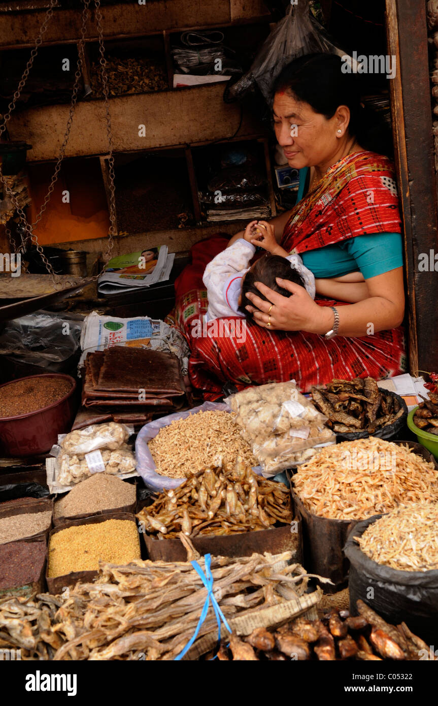 Les népalaises tendant à son bébé et à la recherche après son Herb and Spice shop, la vie des populations ( l ) les Népalais de Katmandou au Népal, , Banque D'Images