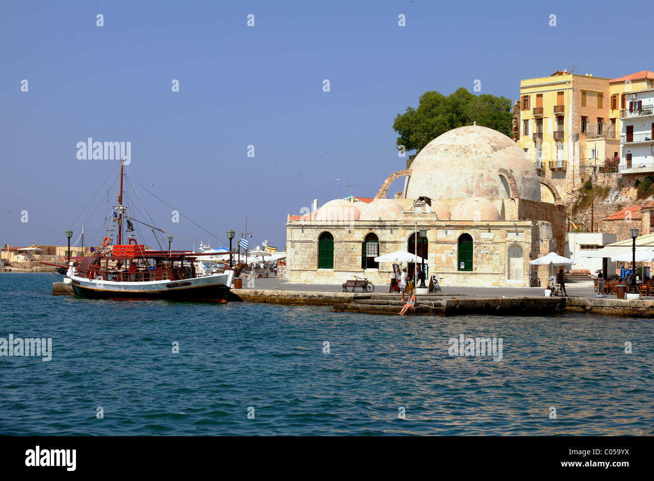 La Canée, Crète, Grèce - 1 juillet 2010 : une vue sur le port de La Canée, avec la Mosquée de janissaires et une caique utilisé comme un touris Banque D'Images