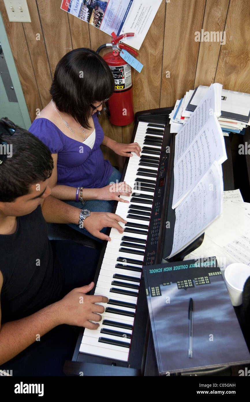 Au lycée garçon et fille jouer du piano en cours de musique au début de la Mission Le Collège École à El Paso au Texas USA Banque D'Images