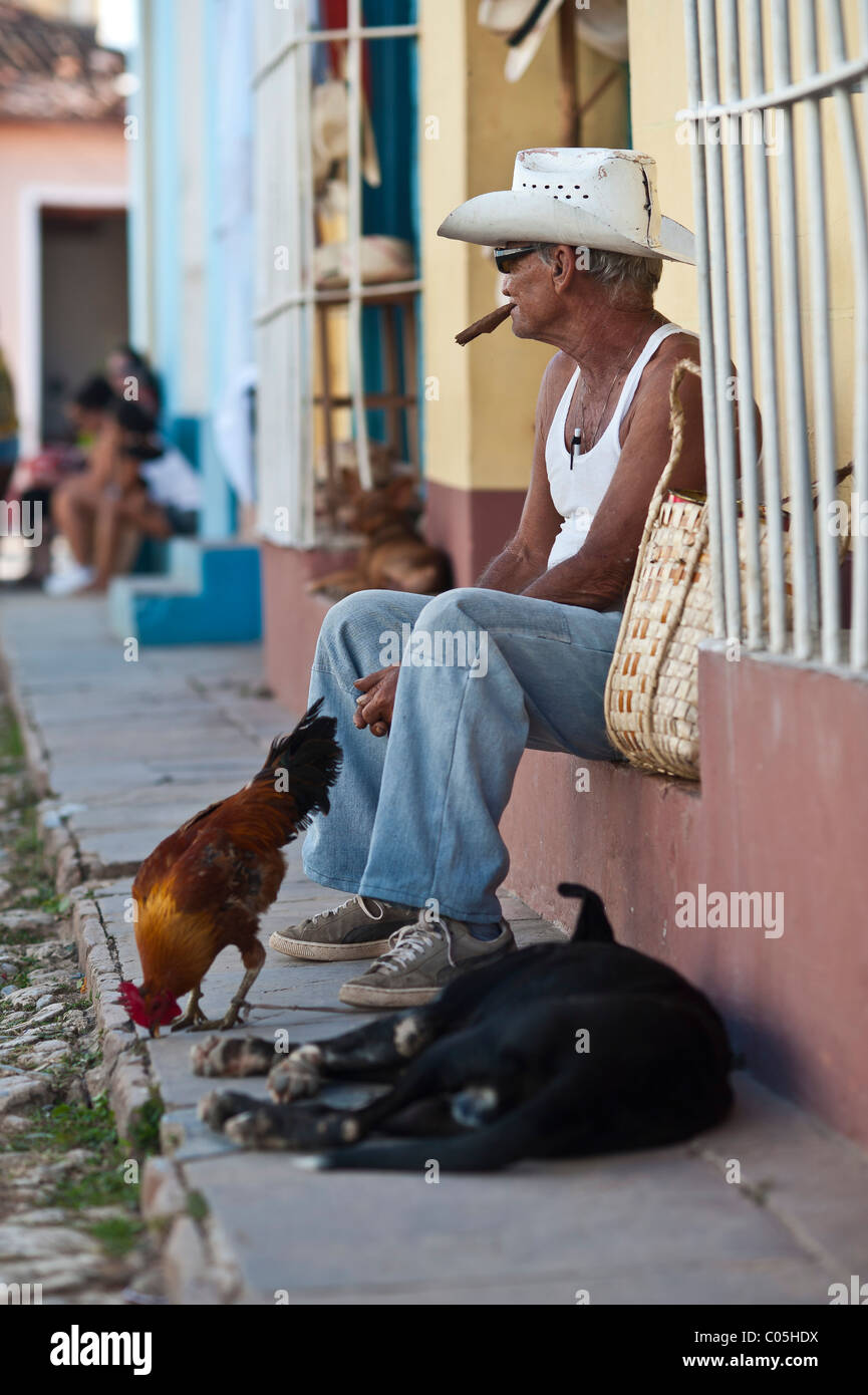 L'homme Local avec du poulet et du chien scène de rue Trinité-province de Sancti Spíritus, Cuba central Banque D'Images