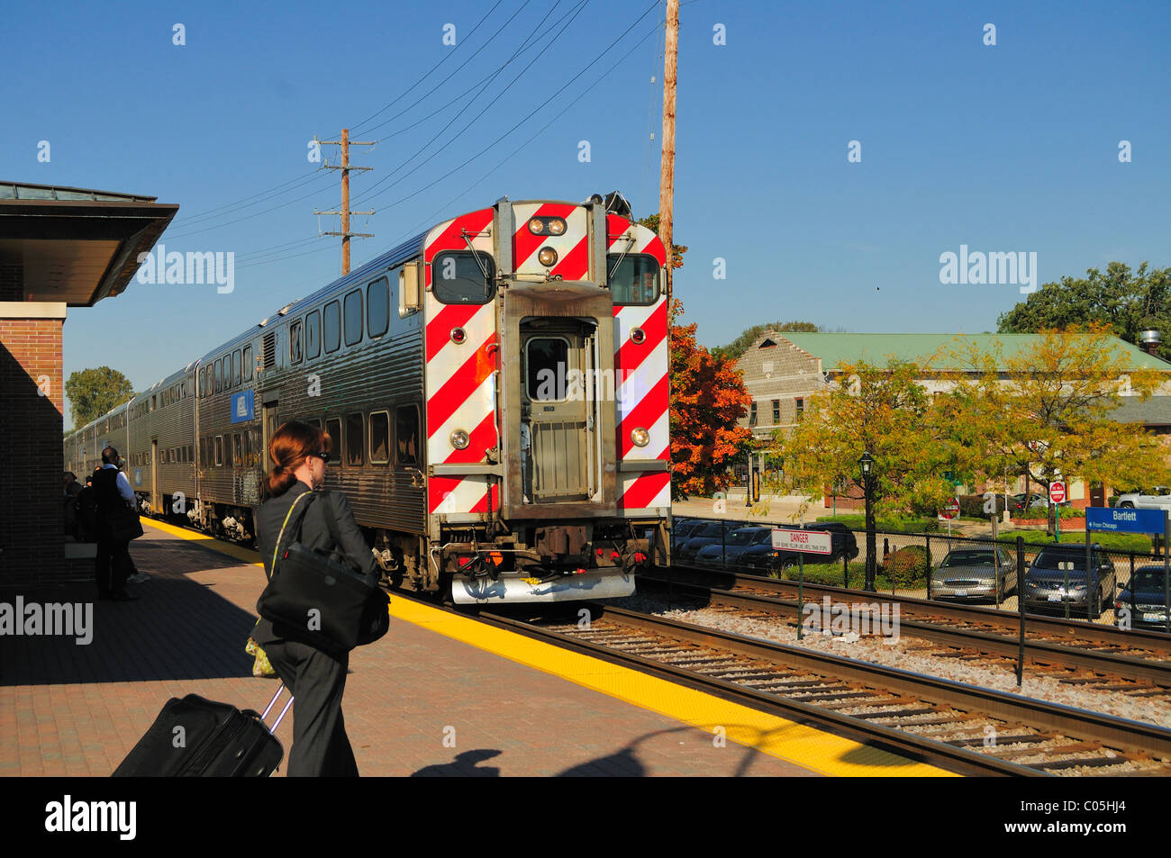 Banlieue Metra train arrivant en gare de la banlieue de Chicago comme Bartlett banlieusards se déplacer à bord du train lorsqu'il s'arrête. Bartlett, Illinois, USA. Banque D'Images