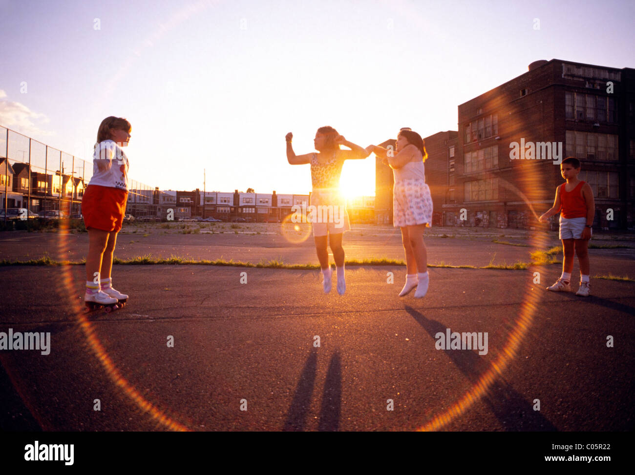 Corde à sauter enfants jouant sur la cour de l'école aire de jeux, Philadelphia, Pennsylvania, USA Banque D'Images