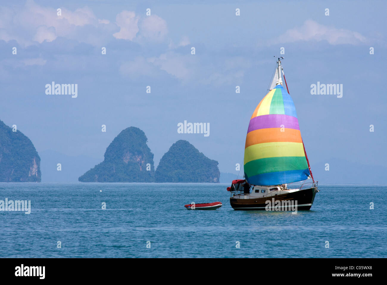 Location de bateaux avec des voiles multicolores naviguant dans la baie de Phang Nga au large de Phuket, Thaïlande Banque D'Images