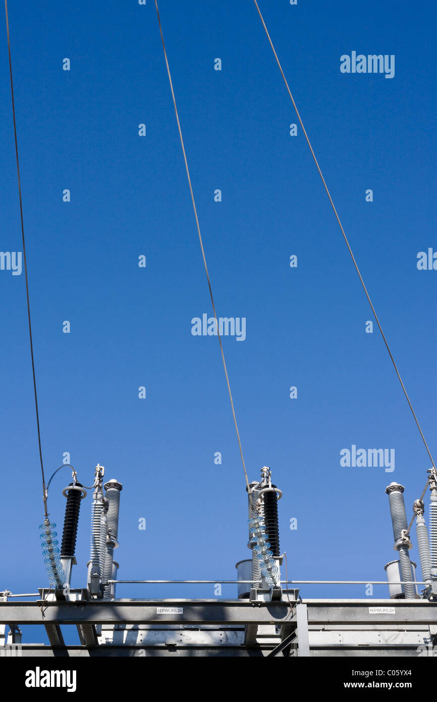 Les fils d'électricité et les isolateurs. Les fils reliés à trois isolateurs en verre sur un grand tableau du transformateur. Banque D'Images