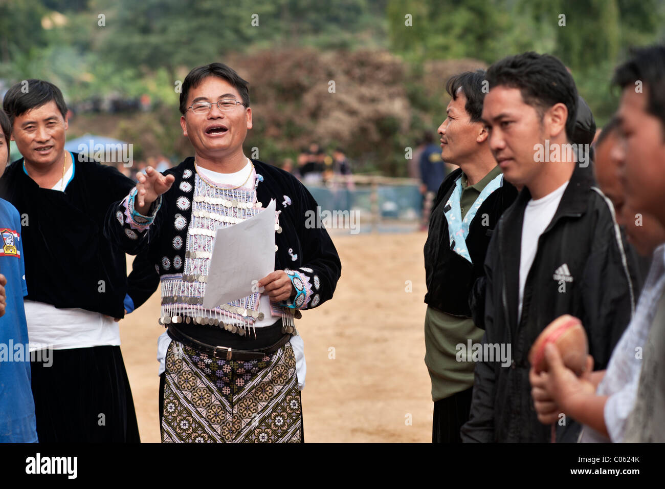 Homme Hmong en donnant des instructions aux participants dans un Tujlub spinning top) concours à un festival du Nouvel an Hmong à Banque D'Images