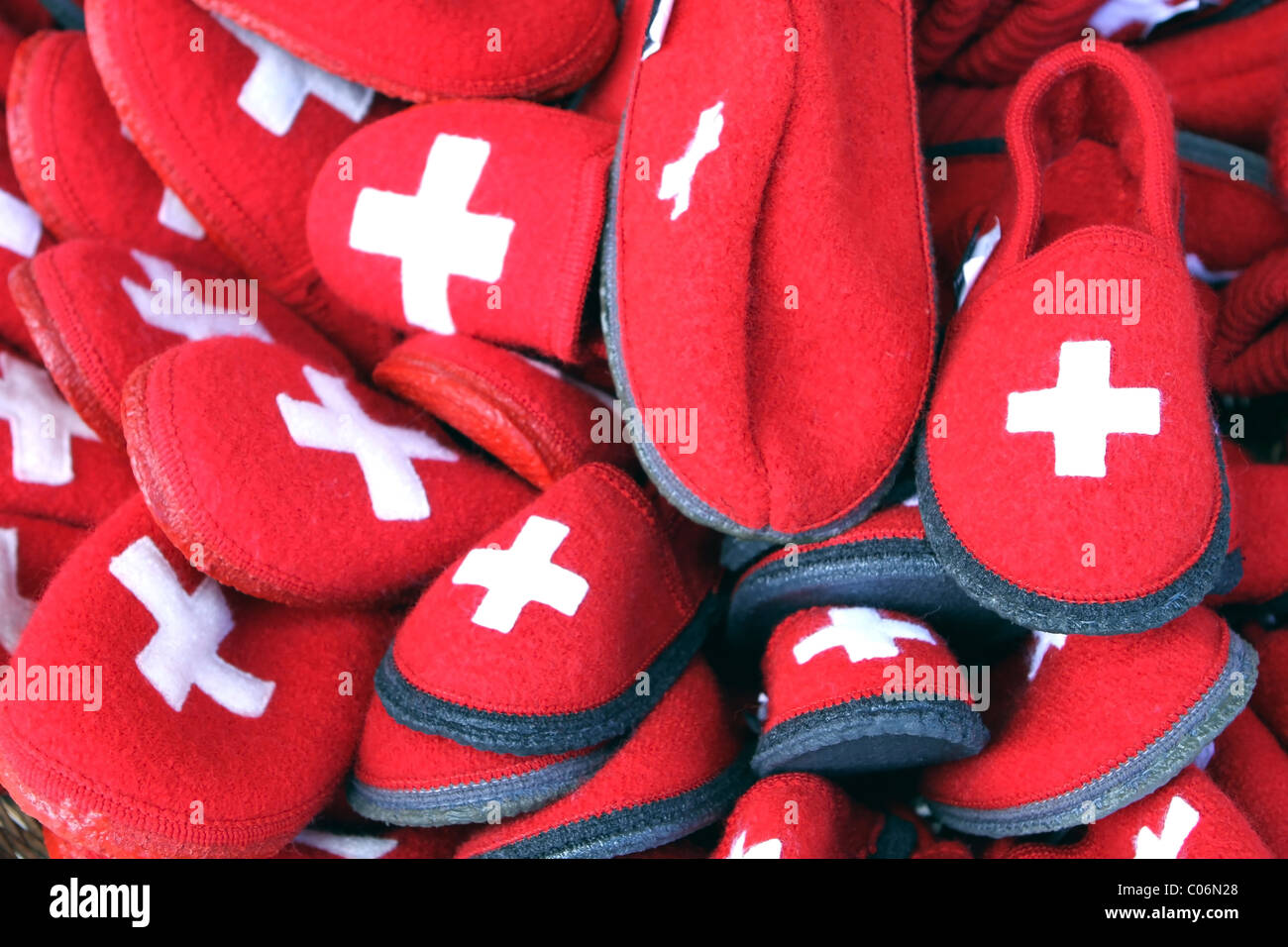 Chaussons - Chaussons rouges qui sont à vendre en Suisse qui ont la croix blanche du drapeau suisse cousues sur eux. Banque D'Images