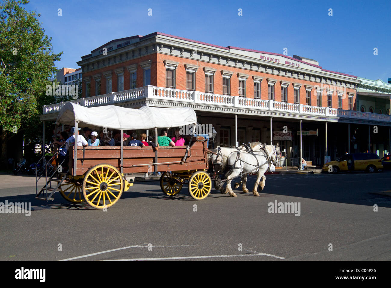 Les touristes voyager dans un wagon couvert à chevaux à Old Sacramento State Historic Park à Sacramento, Californie, USA. Banque D'Images