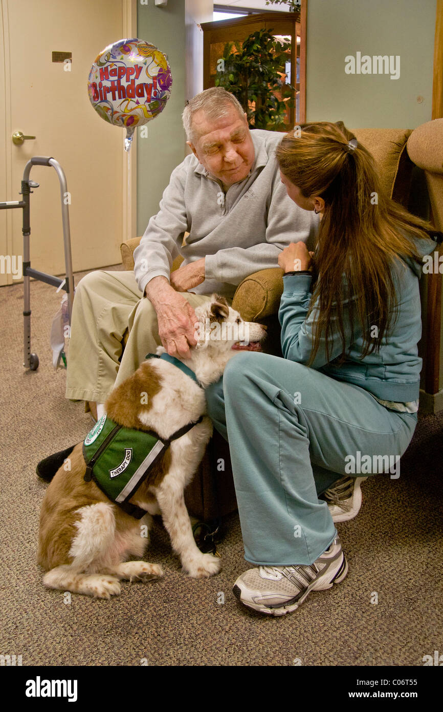 Une femme bénévole de bienfaisance introduit un chien de thérapie d'un patient dans une maison de retraite à Mission Viejo, en Californie. Presse Banque D'Images