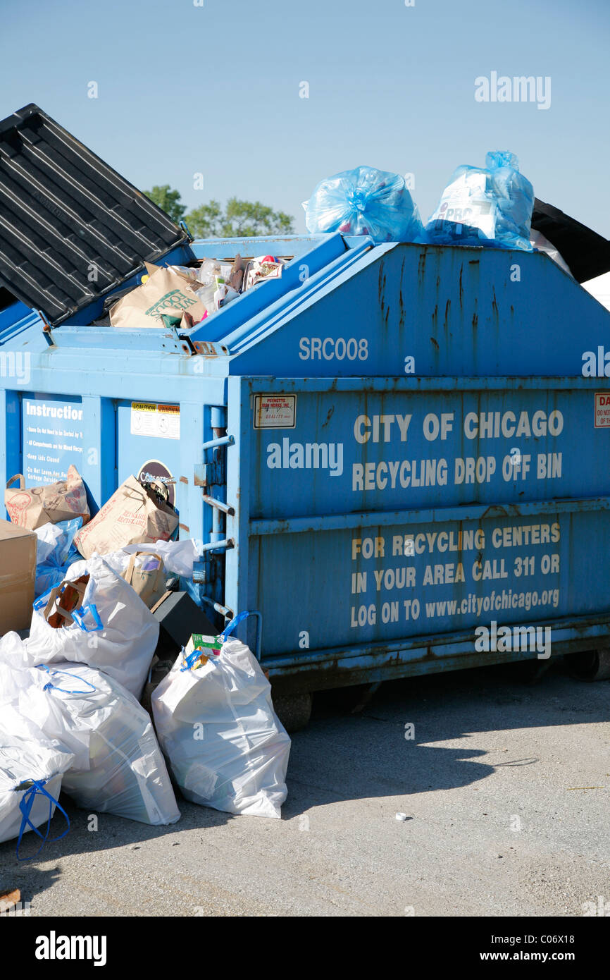 Centre de recyclage contenant drop off déborde de sacs et cartons de produits recyclables. Banque D'Images