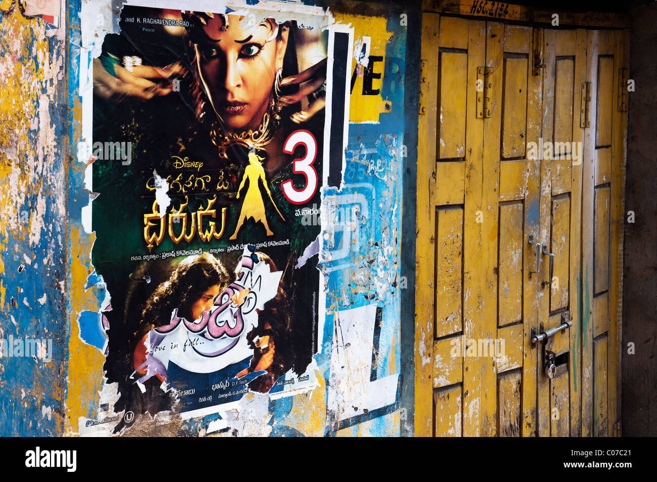 Affiches de films indiens sur un mur en lambeaux d'une vieille maison de l'Inde rurale. L'Andhra Pradesh, Inde Banque D'Images