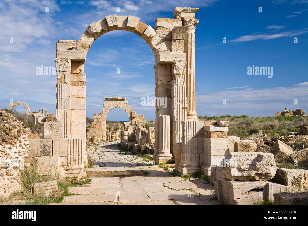L'arc de Trajan sur la Via Trionfale, l'Arc de Tibère à l'arrière, Leptis Magna, Libye, Afrique du Nord Banque D'Images