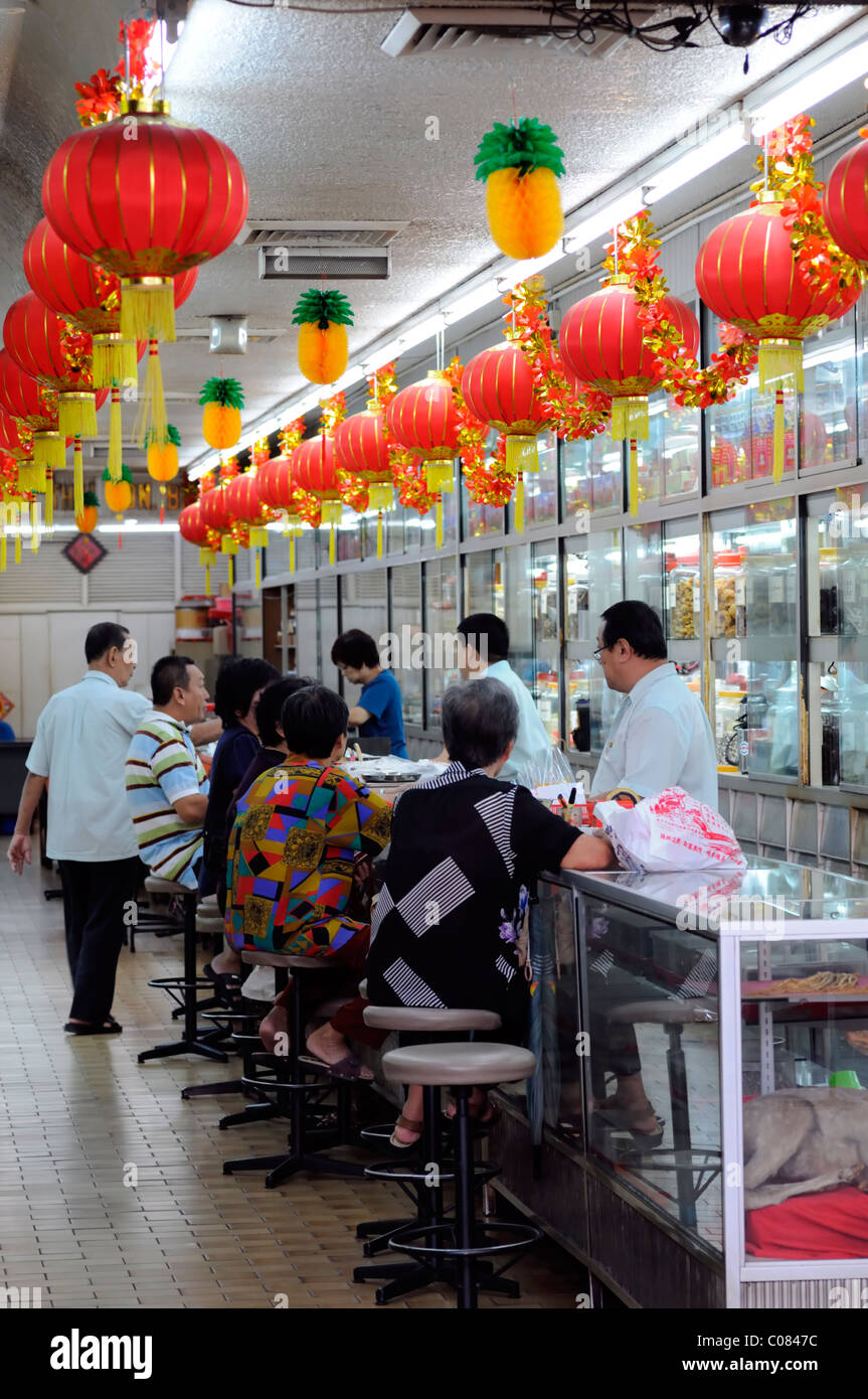 Les gens patients patient en attente d'attente au comptoir d'un petit dispensaire de médecine traditionnelle chinoise health clinic Banque D'Images