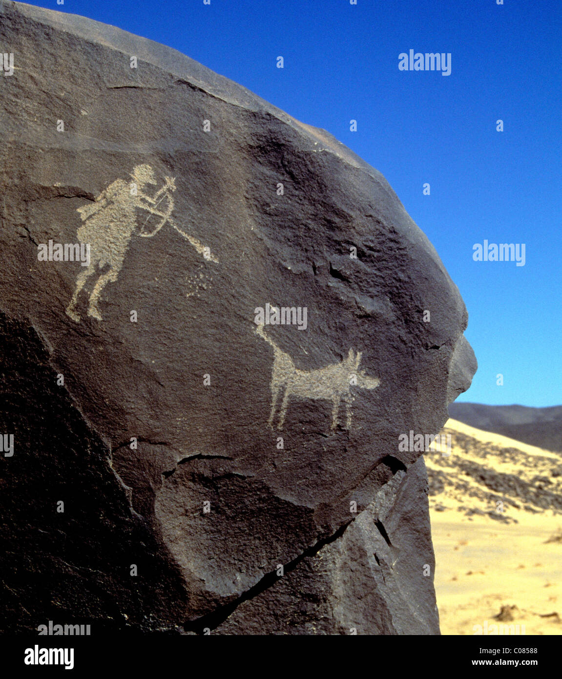 Hunter tirant une flèche à un phacochère gravure sur roche dans l'Est de l'Aïr Niger sud Sahara Banque D'Images