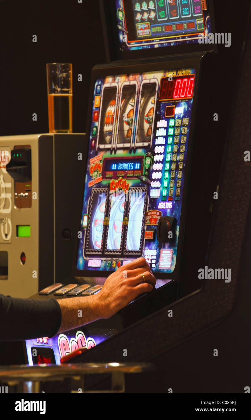 Man playing slot machine Banque D'Images