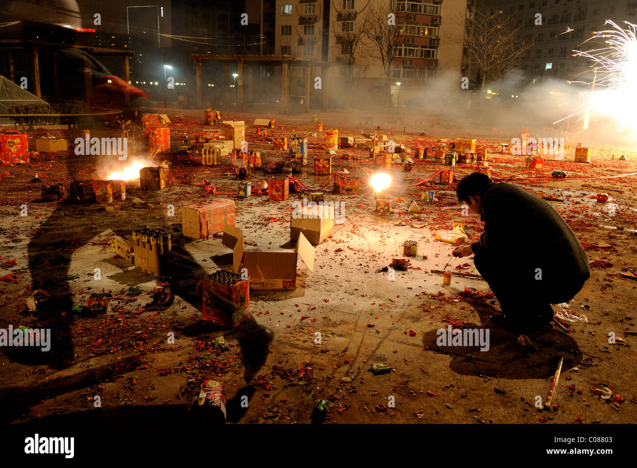 Chine - un homme déclenche un feu d'artifice alors qu'un agent de sécurité dans les scoots Lantern Festival nuit à Beijing.17-Feb-2011 Banque D'Images