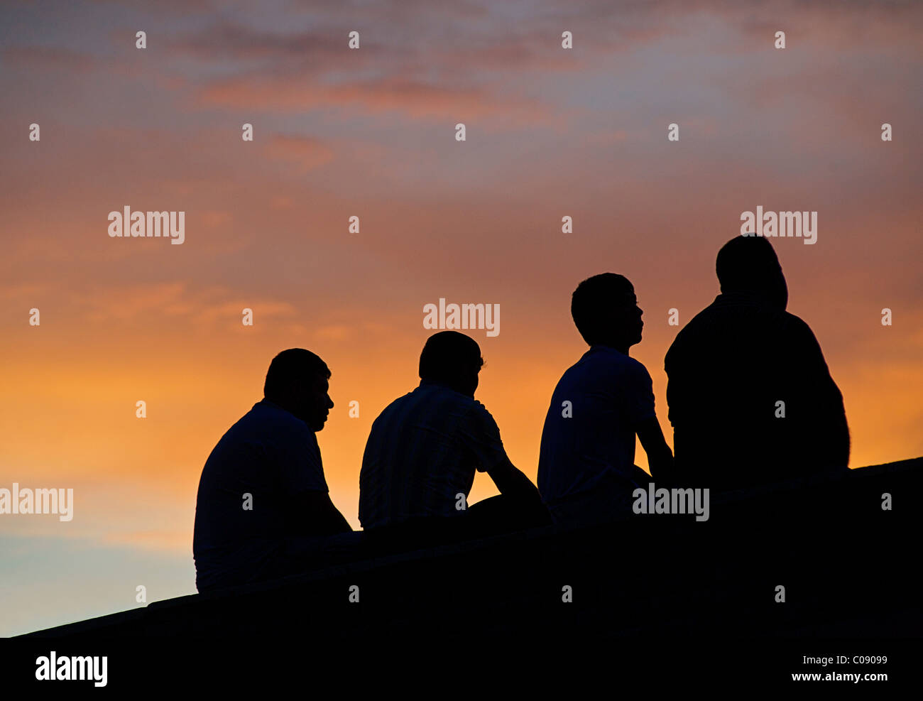 Groupe de 4 hommes Uzbeki silhouetté contre le ciel au crépuscule, Boukhara, Ouzbékistan Banque D'Images