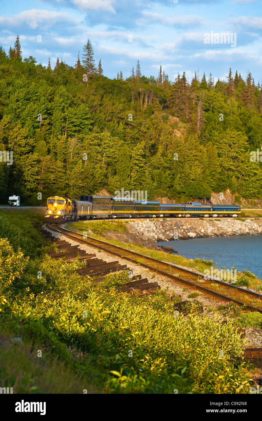 Un train de voyageurs Alaska Railroad arrondit un corner le long du ruisseau d'oiseaux près de Turnagain Arm, Southcentral Alaska, l'été Banque D'Images