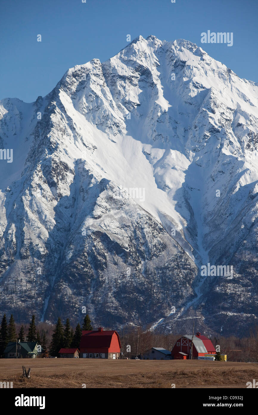 Vue d'une ferme et la grange rouge à la base du pic de Pioneer et les montagnes Chugach, Matanuska-Susitna Valley Banque D'Images