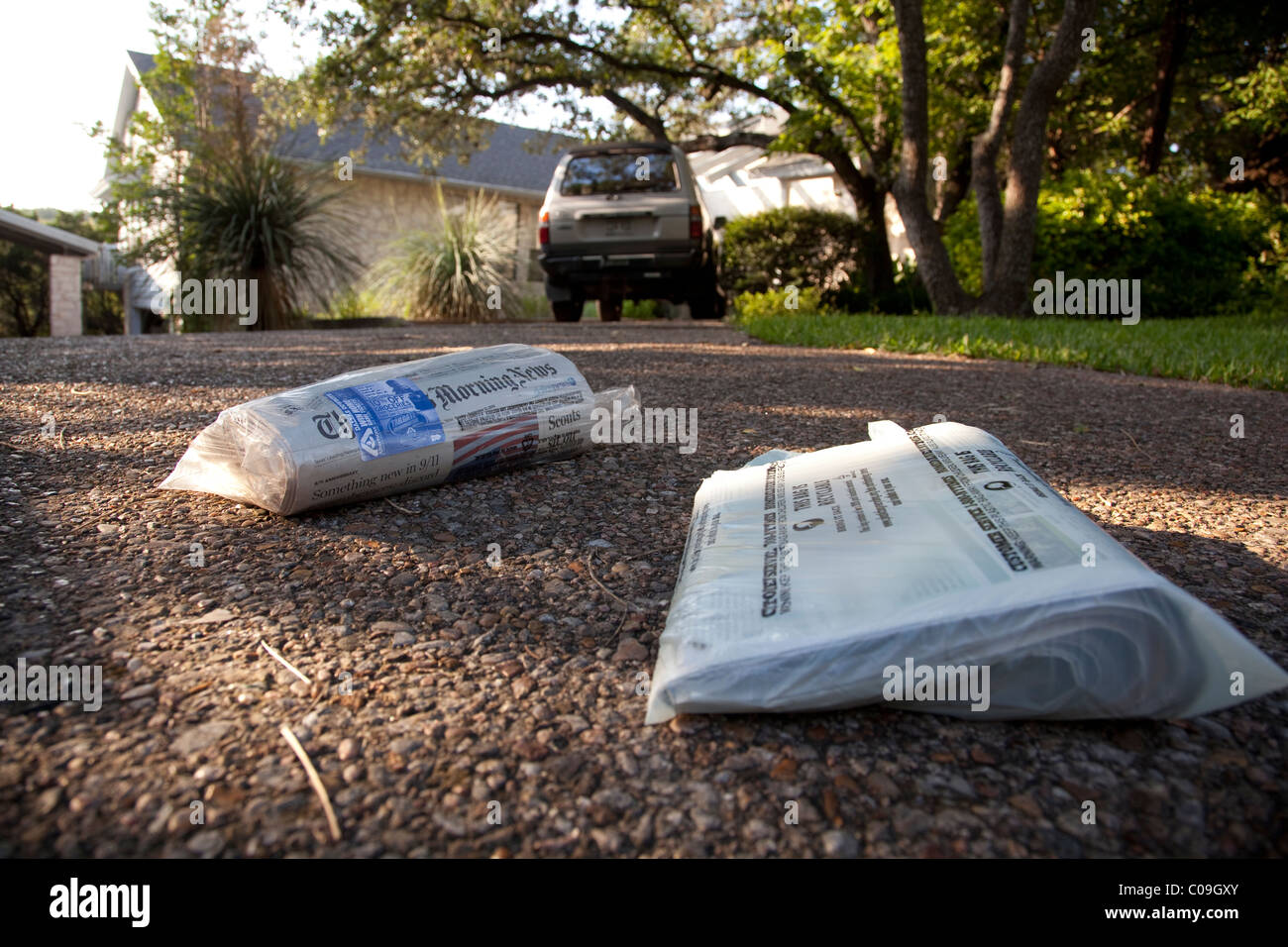 Copie livrés à domicile de quotidiens enveloppés dans des sacs en plastique s'appuie sur entrée de résidence à Austin au Texas Banque D'Images